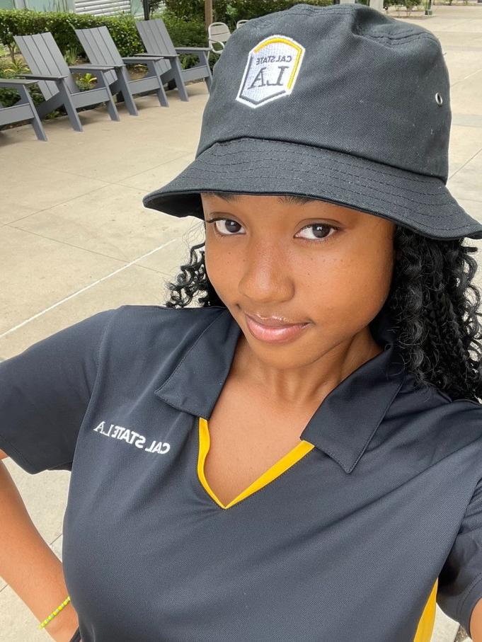 Student in black bucket cap and black polo.